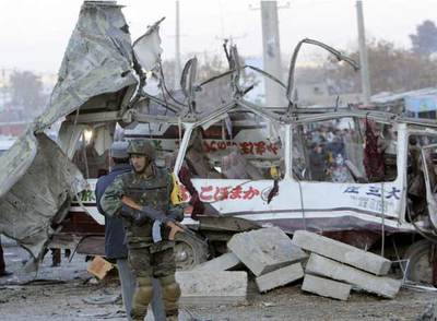 Un soldado afgano hace guardia cerca del autobús contra el que un terrorista suicida empotró un coche bomba, ayer en el sur de Kabul.