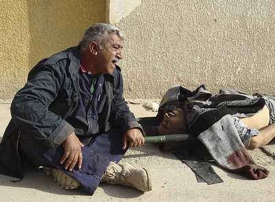 Un hombre llora cerca del cadáver de su hermano, muerto al estallar una bomba.
