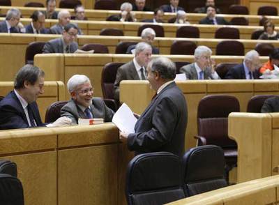 Pedro Solbes habla con el portavoz socialista, Joan Lerma, en el debate de los Presupuestos en el Senado.