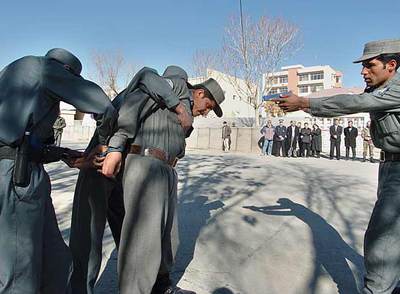 Un grupo de guardias del Parlamento afgano, en un simulacro de arresto durante una ceremonia ayer en Kabul.