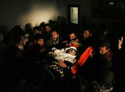 Palestinos llevan el cuerpo de uno de los milicianos que murieron en ataques aéreos del Ejército israelí en la franja de Gaza.