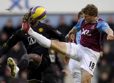 Spector (a la derecha), del West Ham, lucha por el balón con Saha, del Manchester United.