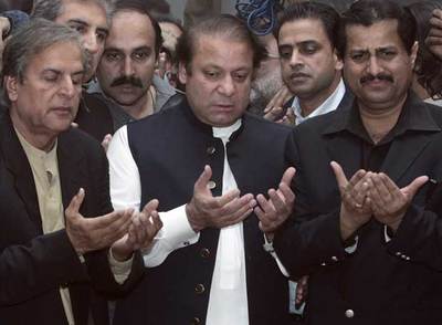 El ex primer ministro Nawaz Sharif (centro) reza durante su visita de ayer a la tumba de Benazir Bhutto.