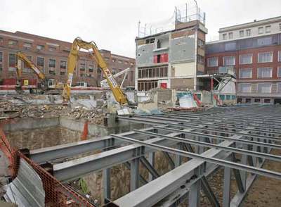 En el centro, la parte del edificio que quedó en pie tras la demolición del pasado sábado. En primer término, las obras del garaje.
