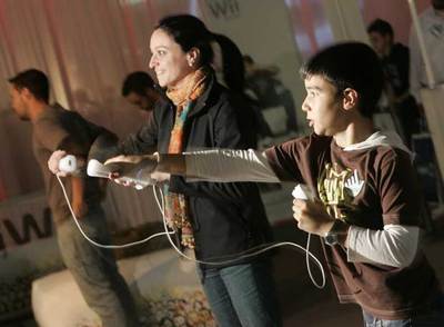 Una mujer y un nilño juegan con una Wii de Nintendo.