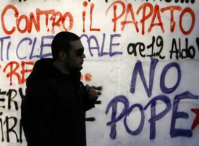 Un estudiante pasa junto a las pintadas contra la visita del Papa a la Universidad de La Sapienza, de Roma.