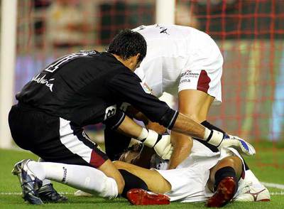 Puerta recibe el auxilio de dos compañeros nada más caer desvanecido sobre el césped del estadio Sánchez Pizjuán el 25 de agosto de 2007, en el partido Sevilla-Getafe.