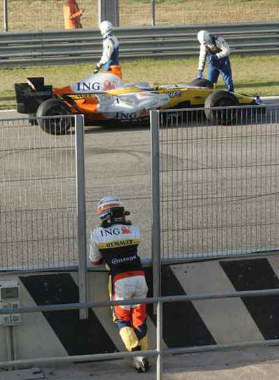 FERNANDO ALONSO OBSERVA SU MONOPLAZA PARADO EN MEDIO DE LA PISTA DE CHESTE.