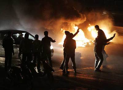 Militantes prosirios junto a las hogueras de neumáticos que cortan la carretera al aeropuerto de Beirut.