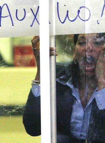 Una rehén pide auxilio desde dentro de la oficina asaltada.