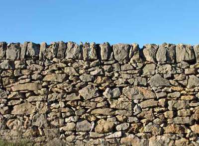 En Vilafranca (Castellón) se registran más de mil kilómetros de paredes de piedra en seco como ésta, además de un millar de casetas de pastor.rnLas casetas tienen falsas bóvedas interiores, a base de losas que van formando círculos concéntricos de radio decreciente.