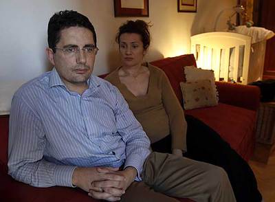 Los padres de Álvaro, en su domicilio con la cuna del bebé al fondo.