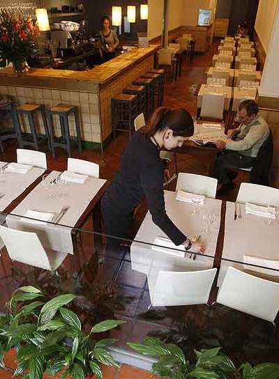 Arriba, el comedor de Embat. Abajo, lomo de cordero con requesón de cabra.