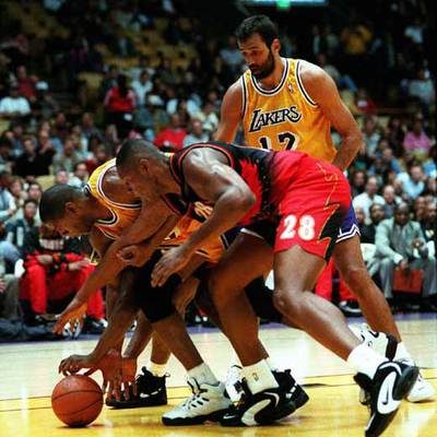 Arriba, Divac junto a Magic Johnson y Lang (de Atlanta) en un partido de los Lakers de 1996.