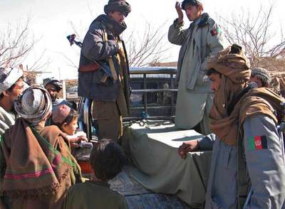 Policías afganos trasladan en una furgoneta el cadáver de una de las víctimas del atentado del domingo en Kandahar.