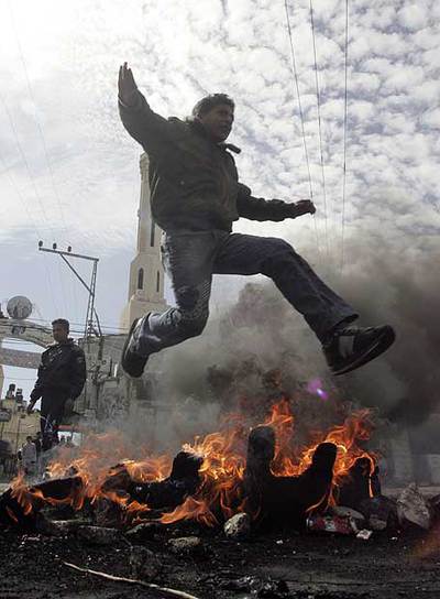 Un joven salta sobre neumáticos incendiados cerca de Nablús.