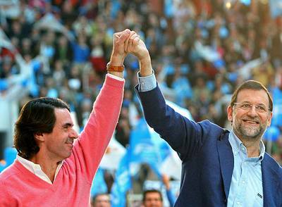El ex presidente José María Aznar, que apareció por sorpresa en el mitin del PP en León, levanta la mano de Mariano Rajoy.