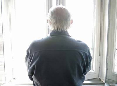 El premio Nobel italiano mira a través de una de las ventanas de su domicilio milanés,