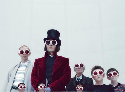 Johnny Depp, en el centro, con levita roja, en la visita a su factoría en  Charlie y la fábrica de chocolate. 