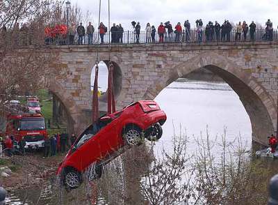 Varios curiosos observan las labores de recuperación del vehículo que cayó al río Duero en Zamora.