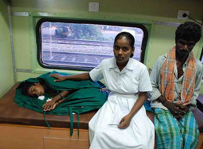 Una paciente es atendida por su padre y una enfermera tras ser operada en el tren-hospital.