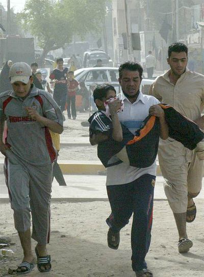 Un iraquí corre para llevar a un niño herido al hospital en Bagdad.