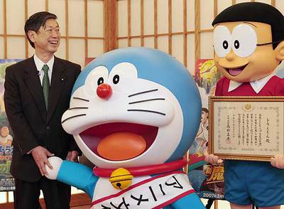 El ministro de Exteriores, Masahiko Komura, con el gato-robot  Doraemon  y Nobita.