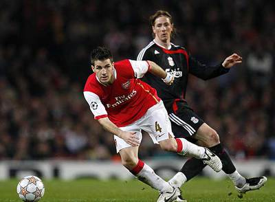 Cesc se lleva el balón ante Fernando Torres.