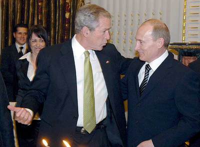 George W. Bush (izquierda) conversa con Vladímir Putin durante una cena oficial celebrada el jueves pasado en Bucarest.