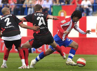 Agüero se lleva el balón ante Bruno y Carlos García.
