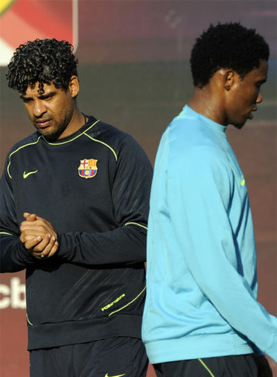 Eto'o pasa junto a Frank Rijkaard en un entrenamiento.