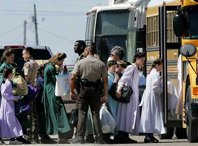 Mujeres y niños rescatados del rancho Anhelo de Sion en Tejas durante su traslado en autobuses escolares.