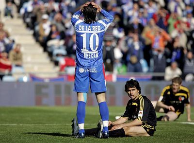 De la Red, con Ayala y Sergio tirados en el césped, se lamenta tras chutar fuera a puerta vacía.