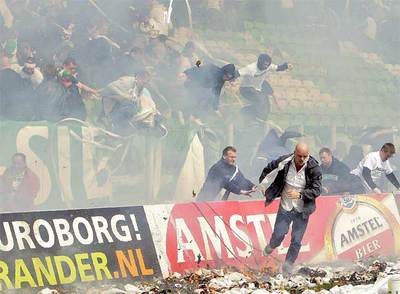 Varios espectadores huyen de la grada en la que se produjo el incendio.