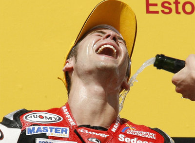 Álvaro Bautista celebra su victoria en el podio del circuito de Estoril.