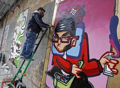 Varios  grafiteros  decoraron ayer la fachada de la futura sede del Colegio de Arquitectos.