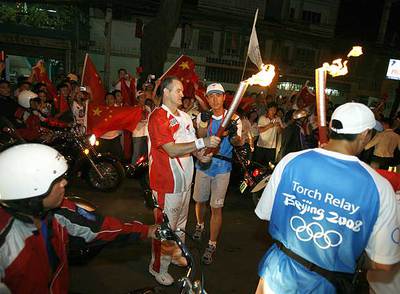 Un atleta toma el relevo de la antorcha olímpica en Ciudad Ho Chi Minh.
