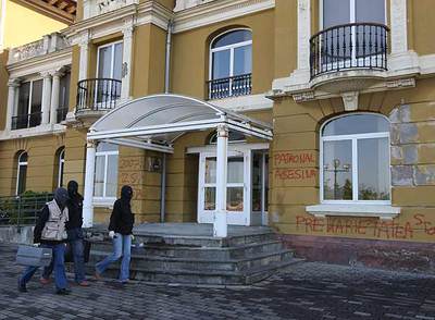 Tres  ertzainas  pasan frente a la fachada del edificio donostiarra atacado por ETA.