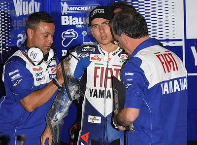 Los mecánicos colocan una protección en el antebrazo a Jorge Lorenzo antes de la carrera.