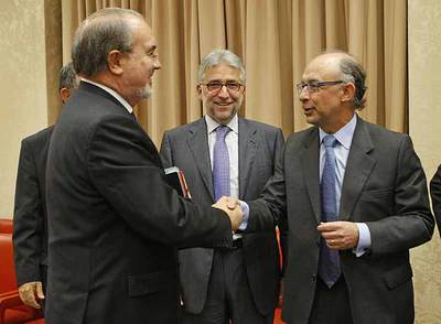 Pedro Solbes saluda al portavoz de Economía del PP, Cristóbal Montoro, en el Congreso.