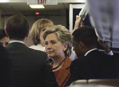 Hillary Clinton, rodeada ayer de colaboradores en el avión que utiliza en su campaña electoral.