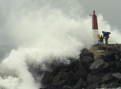 Arriba, pasajeros de un tren de media distancia evacuados en Torredembarra. Abajo, una familia observa el rompeolas, a la entrada del puerto de Empuriabrava, en Castelló d'Empúries.rn  josep lluís sellart