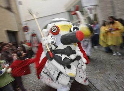 Una calle de Segovia en el momento de pasar el espectacular pasacalles  Merma nuncamuere  con los muñecos creados por Miró y Biaxas.