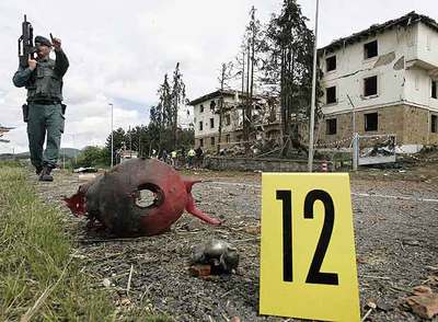Un guardia  vigila una zona con restos lanzados por la explosión a decenas de metros del cuartel.