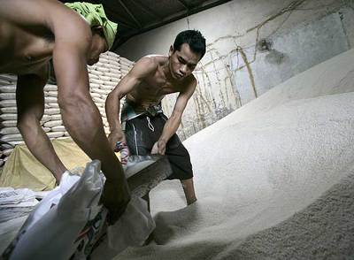 Dos trabajadores empaquetan arroz en Yakarta, Indonesia.