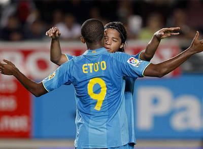 Giovani celebra uno se sus goles con Eto'o.