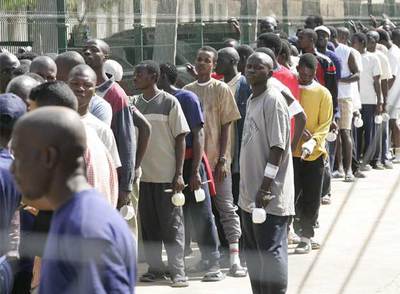 Inmigrantes subsaharianos hacen cola para su turno de comida en un centro de Melilla, en 2005.