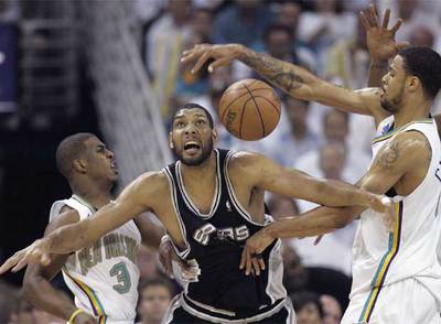 Duncan (en el centro) pugna por el balón con Paul (a la izquierda) y Chandler durante el séptimo partido de los Spurs contra los Hornets.