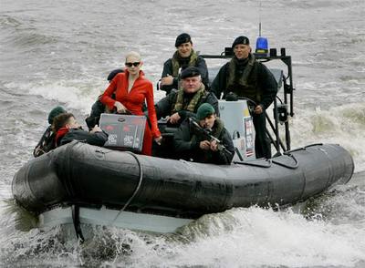 La modelo Tuuli Shipser, escoltada por militares, lleva en un maletín los primeros ejemplares del libro durante la presentación ayer en Londres.