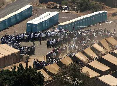 Inmigrantes subsaharianos sin papeles hacen cola para obtener comida en el centro de acogimiento de Las Raíces, en Tenerife. rn